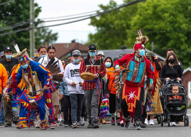Members of the community of the Kahnawake Mohawk Territory, Quebec march through the town on May 30, 2021, to commemorate the news that a mass grave of 215 Indigenous children were found at the Kamloops Residential School in British Columbia. Peter McCabe / Agence France-Presse