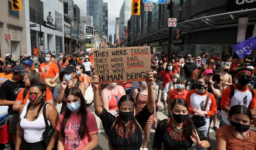 People take part in a march on Canada Day in Toronto July 1, after the discovery of hundreds of unmarked graves on the grounds of former residential schools for Indigenous children in Canada. (CNS/Reuters/Carlos Osorio)