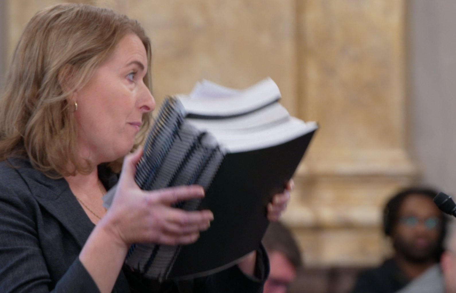 Ray Pfeffer Ohioans for Child Protection co-founder Rebecca Surendorff shows the Ohio Senate Judiciary Committee four binders of text messages former priest Tony Cutcher sent to a 14-year-old boy on Dec. 4, 2024.